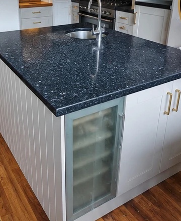 White panelled kitchen island with black granite worktop and wine cooler